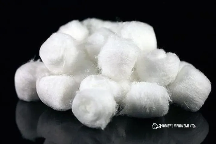 Using Cotton Balls to Clean the Corners of Shower Tiles